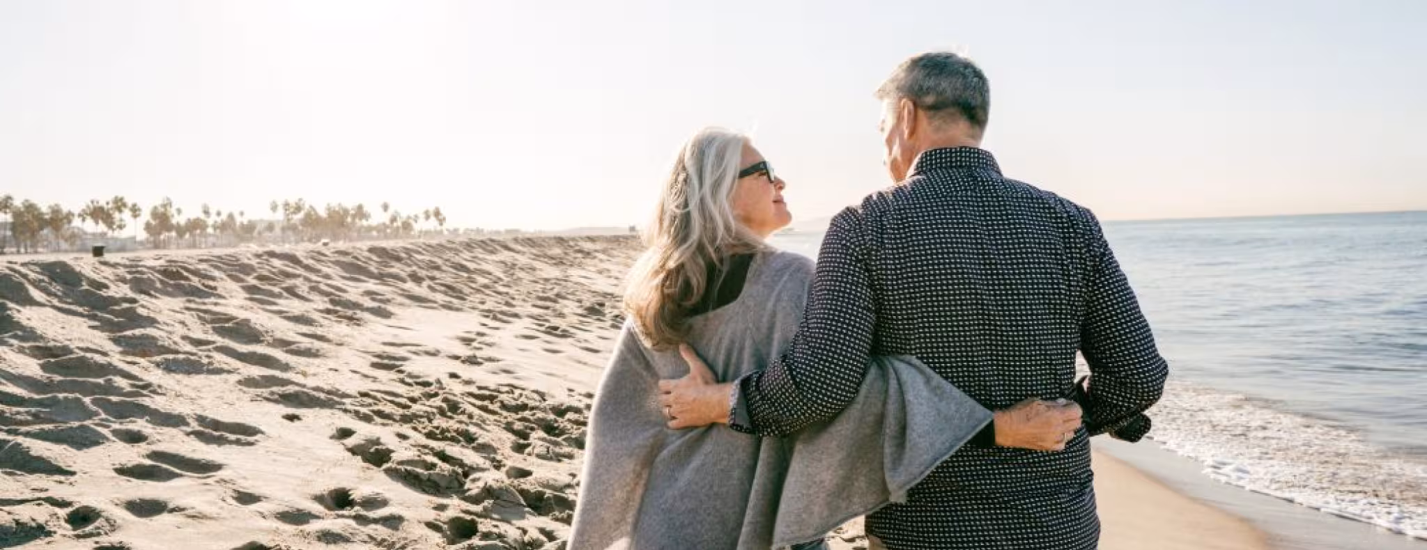 Older couple walking on beach