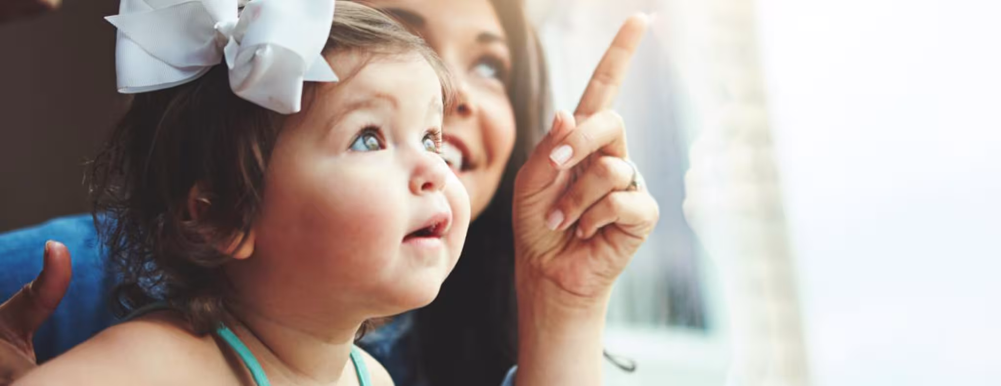 Mother with toddler looking out window