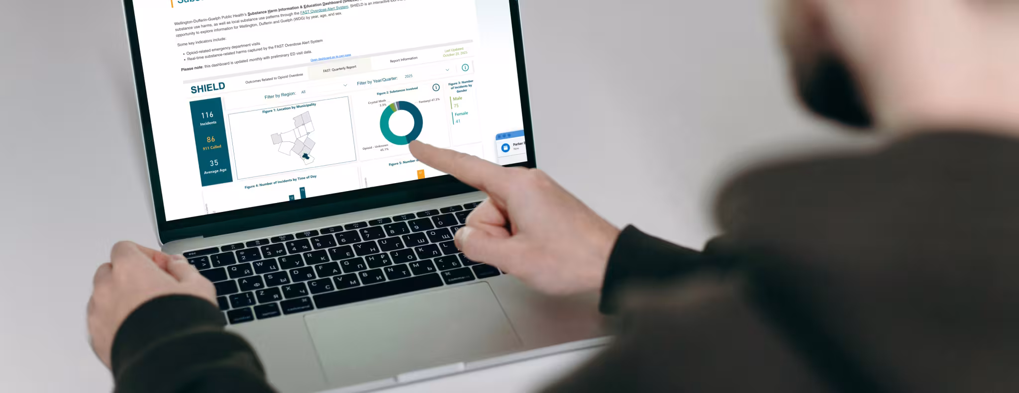 Man looking at the SHIELD dashboard sitting at his desk pointing at the screen
