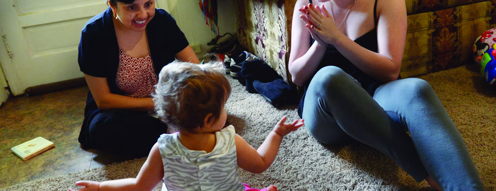 Home visitor working with toddler and mom