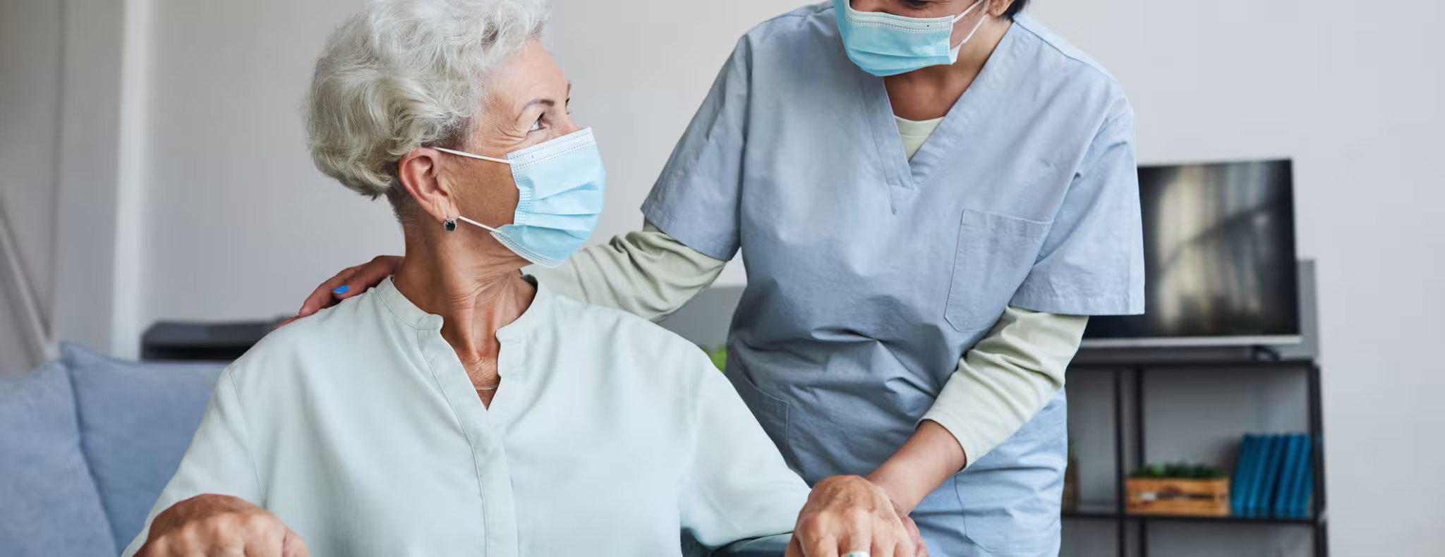 Young Nurse Helping Senior in Wheelchair 