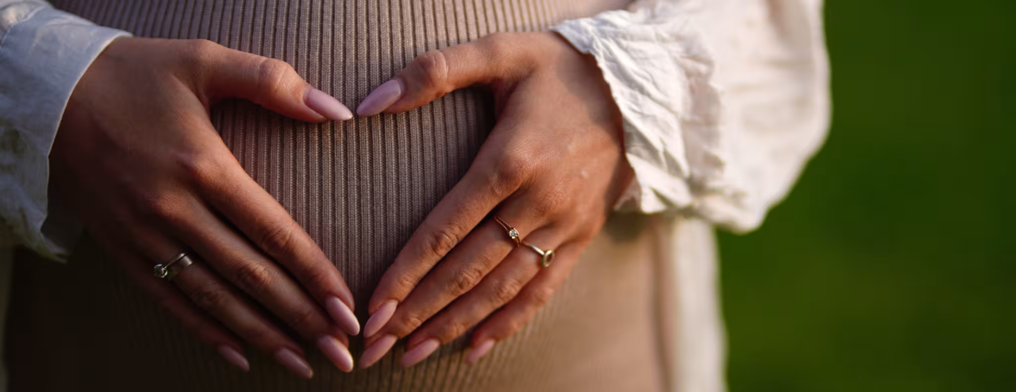 Pregnant woman making heart shape on her belly