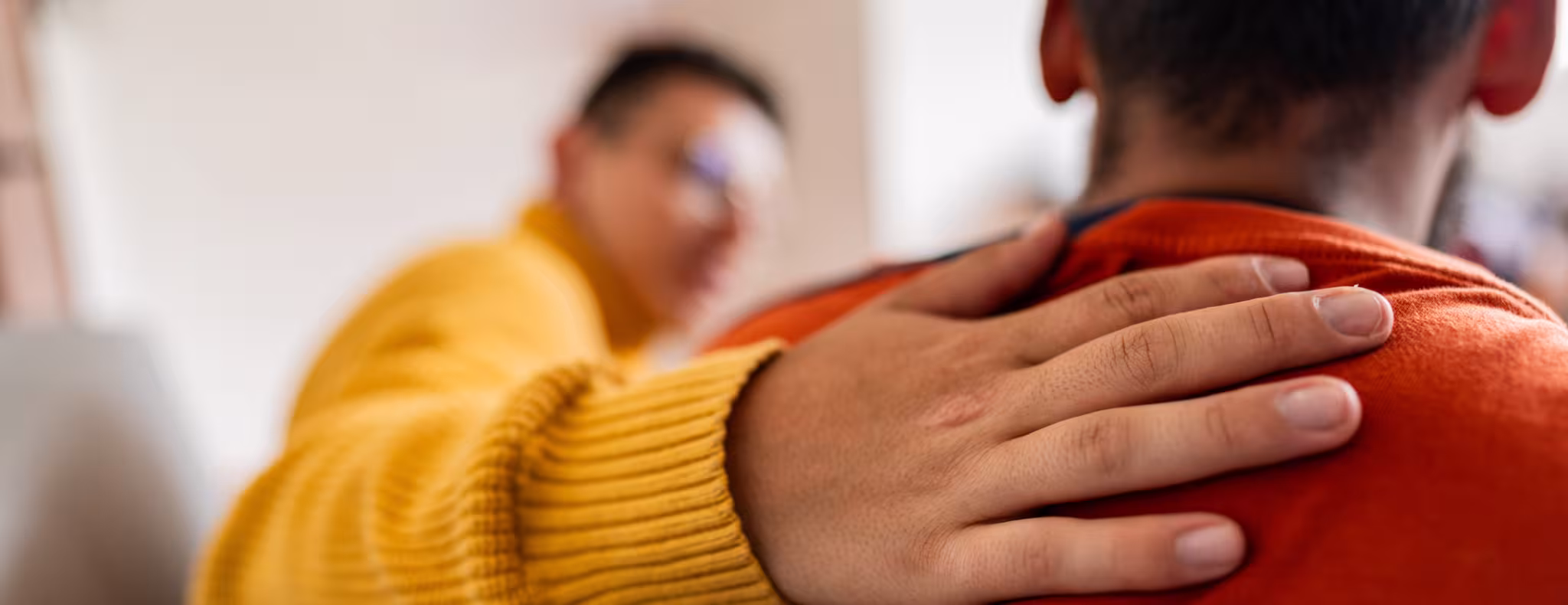 Close-up image of a counselor with hand on patient's shoulder
