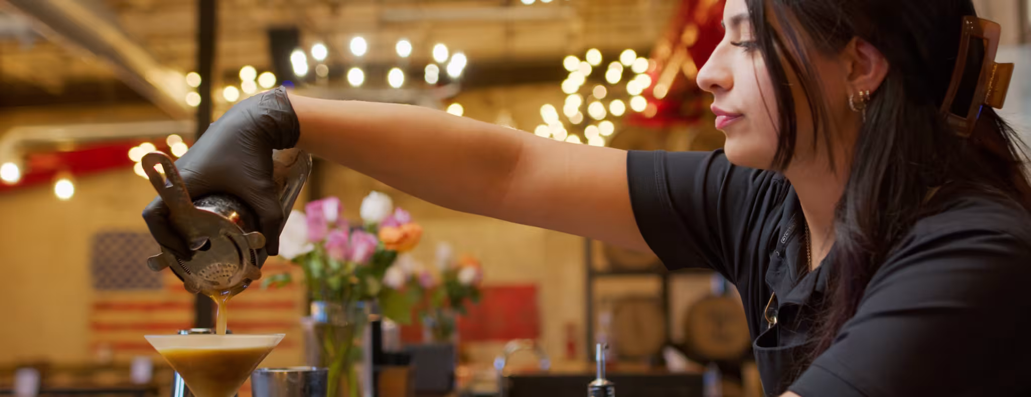 Female bartender pouring martini