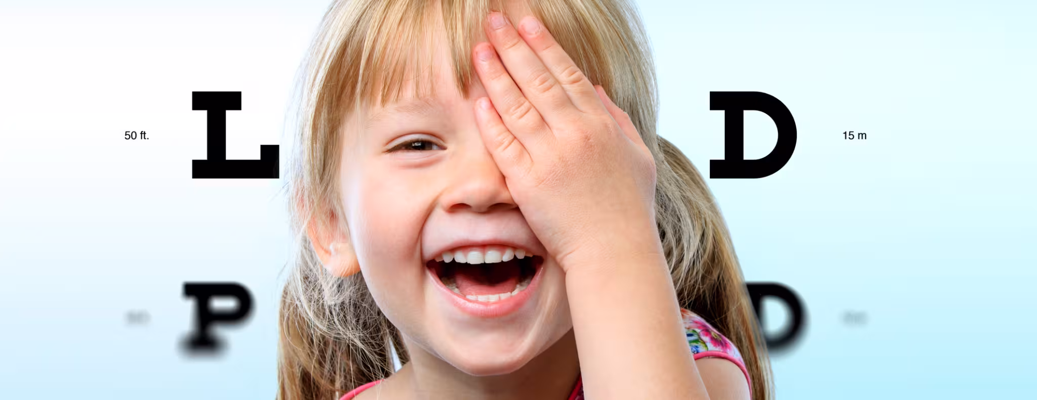 Close up face portrait of happy girl having fun at vision test.