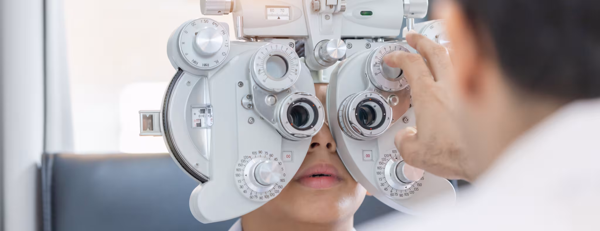 Boy doing eye test checking examination with optometrist