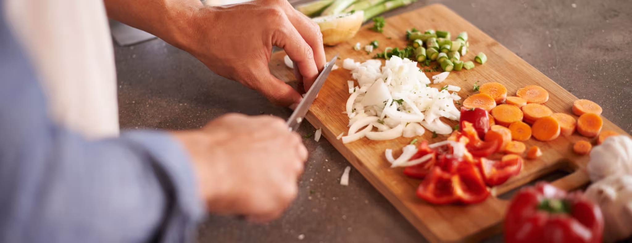 Cropped shot of a man chopping vegetables on a countertop