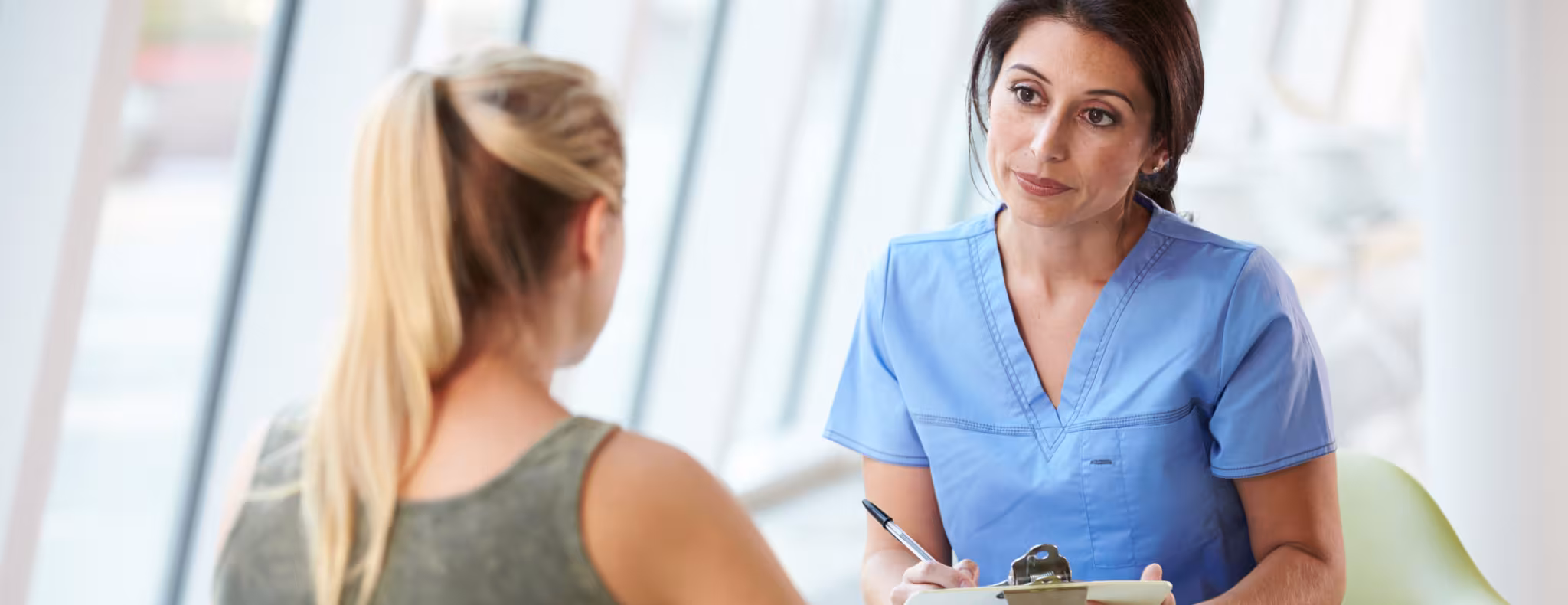 Nurse Meeting With Teenage Girl with clipboard
