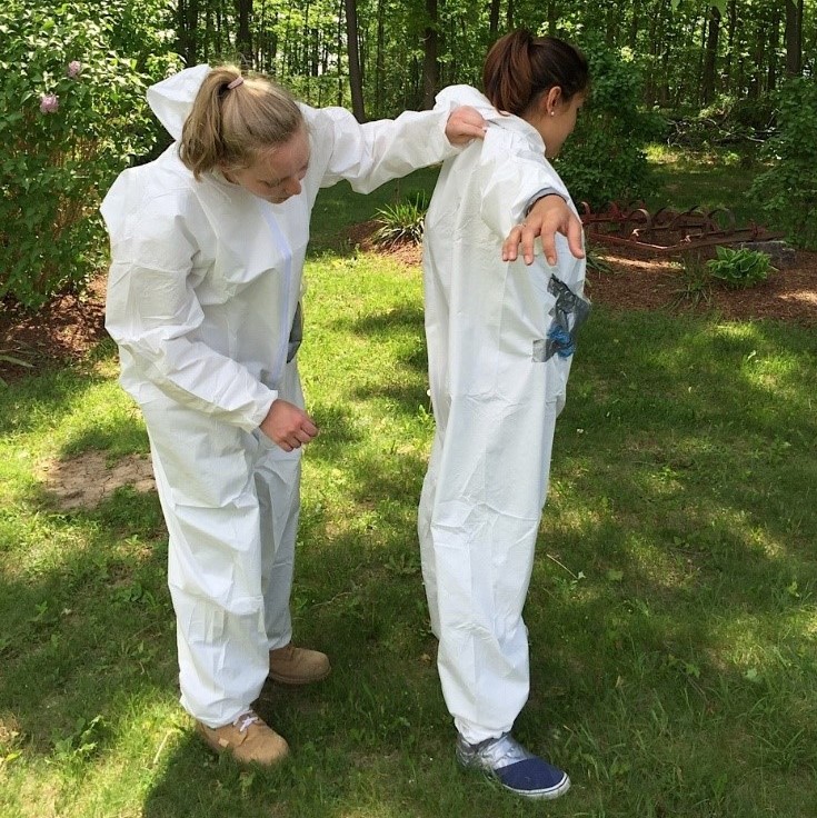 Public Health Inspector scanning the back of another inspector for ticks